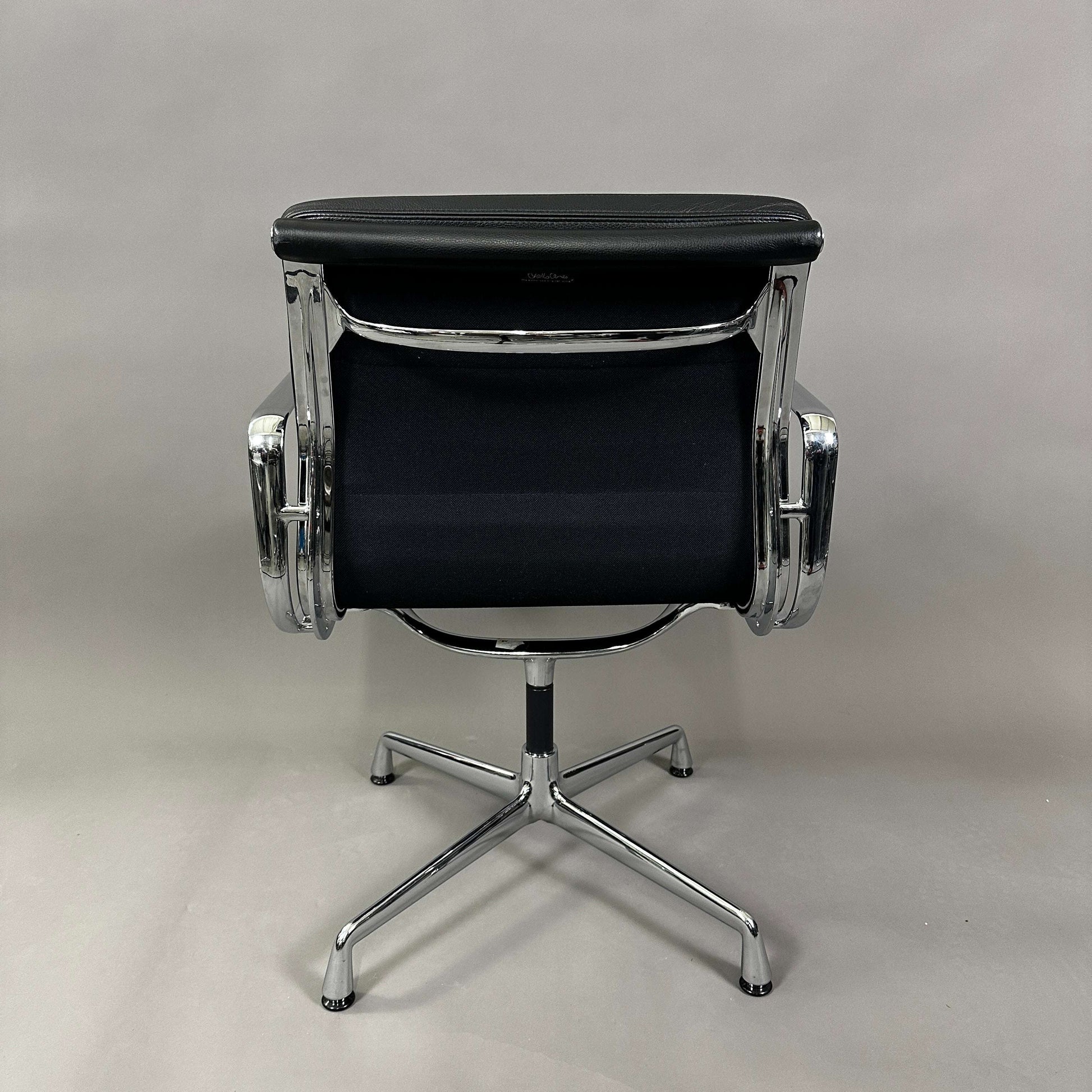 Back view of Vitra EA 208 swivel chair with black soft padded leather seat and chrome frame