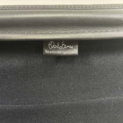 Close-up of black leather tag on Vitra EA 216 Eames Alu Chair soft pad upholstery