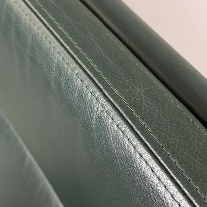 Nahaufnahme des dunkelgrünen Lederbezugs des Vitra EA 219 Stuhls mit Chromgestell