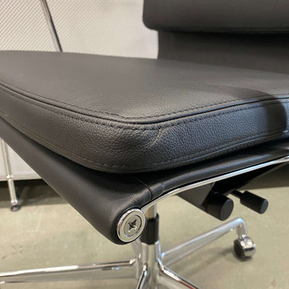 Close-up of Vitra EA 219 office chair in black leather with chrome frame and adjustable reclining mechanism.