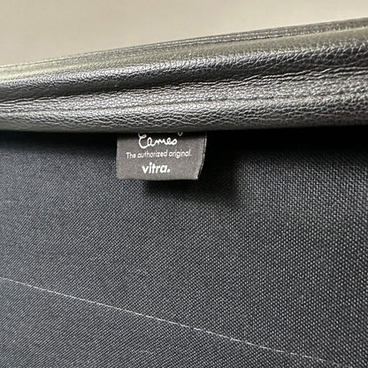 Detailaufnahme des schwarzen Lederbezugs und Vitra Eames EA 219 Labels am polierten Aluminiumstuhl