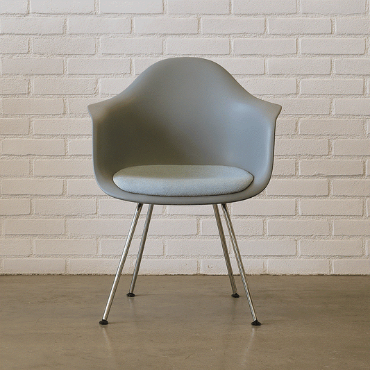 Vitra Eames Plastic Armchair DAX in mauvegrau mit Metallbeinen vor weißer Ziegelwand in sehr gutem Zustand