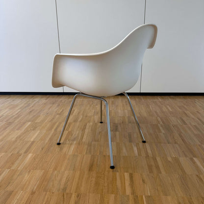 Vitra Eames Plastic Armchair weiß mit verchromtem Metallgestell auf Parkettboden, Rückansicht