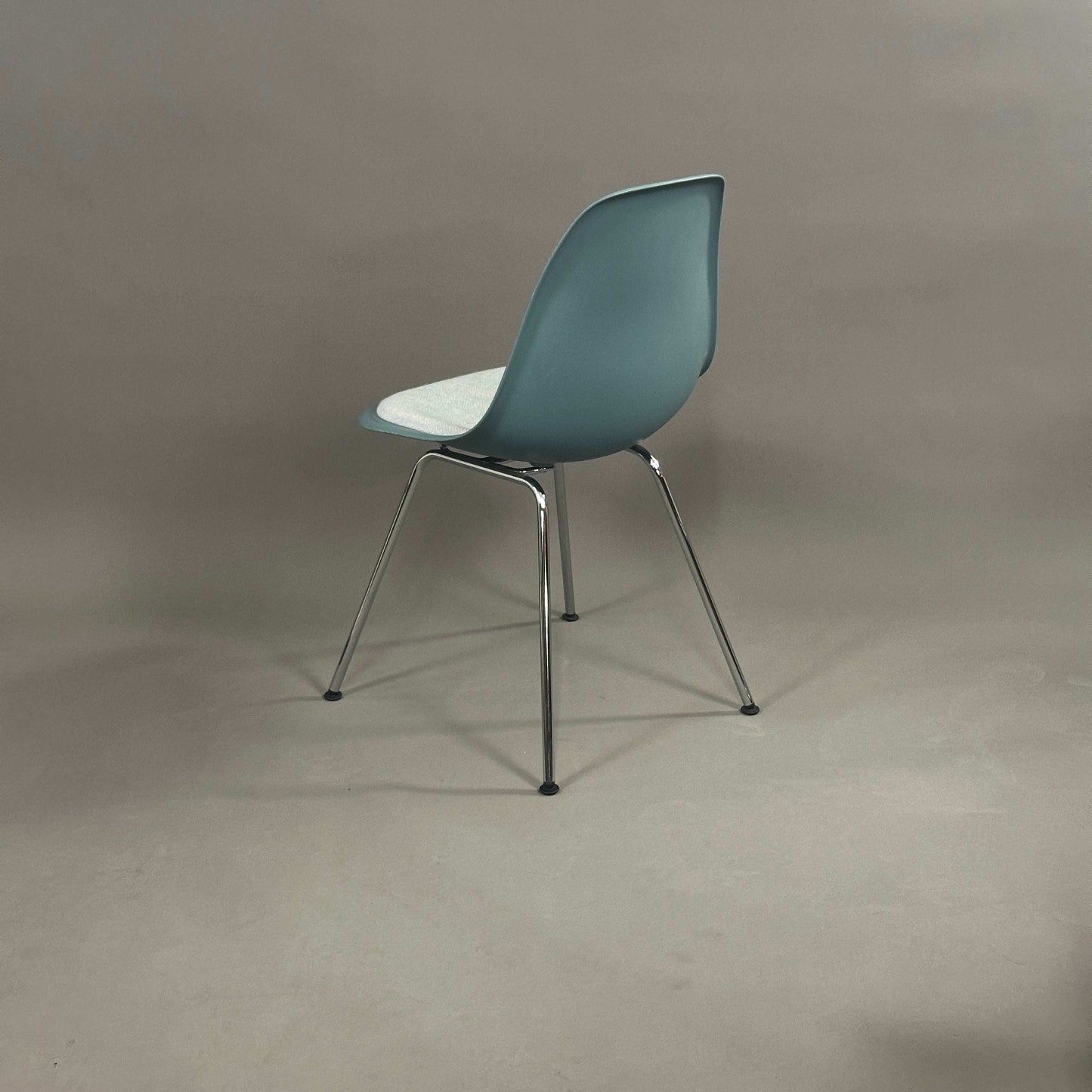 Vitra Eames Plastic chair DSX in Petrol mit weiß-blauem Sitzkissen und chromgestell von hinten