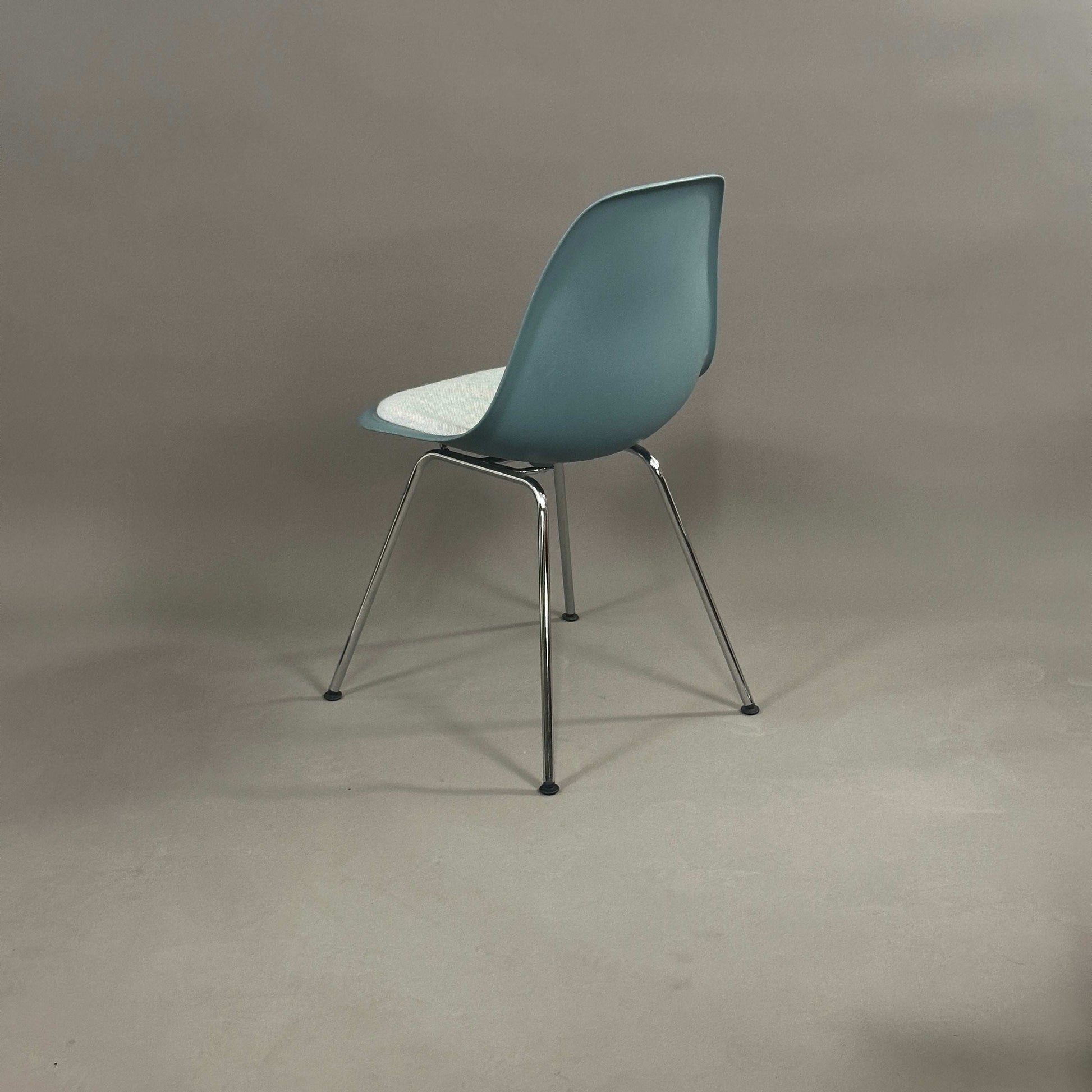 Vitra Eames Plastic chair DSX in Petrol mit weiß-blauem Sitzkissen und chromgestell von hinten
