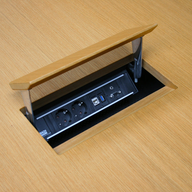 Vitra Eames Segmented Table with open oak veneer electrification unit, showing power outlets and data ports.