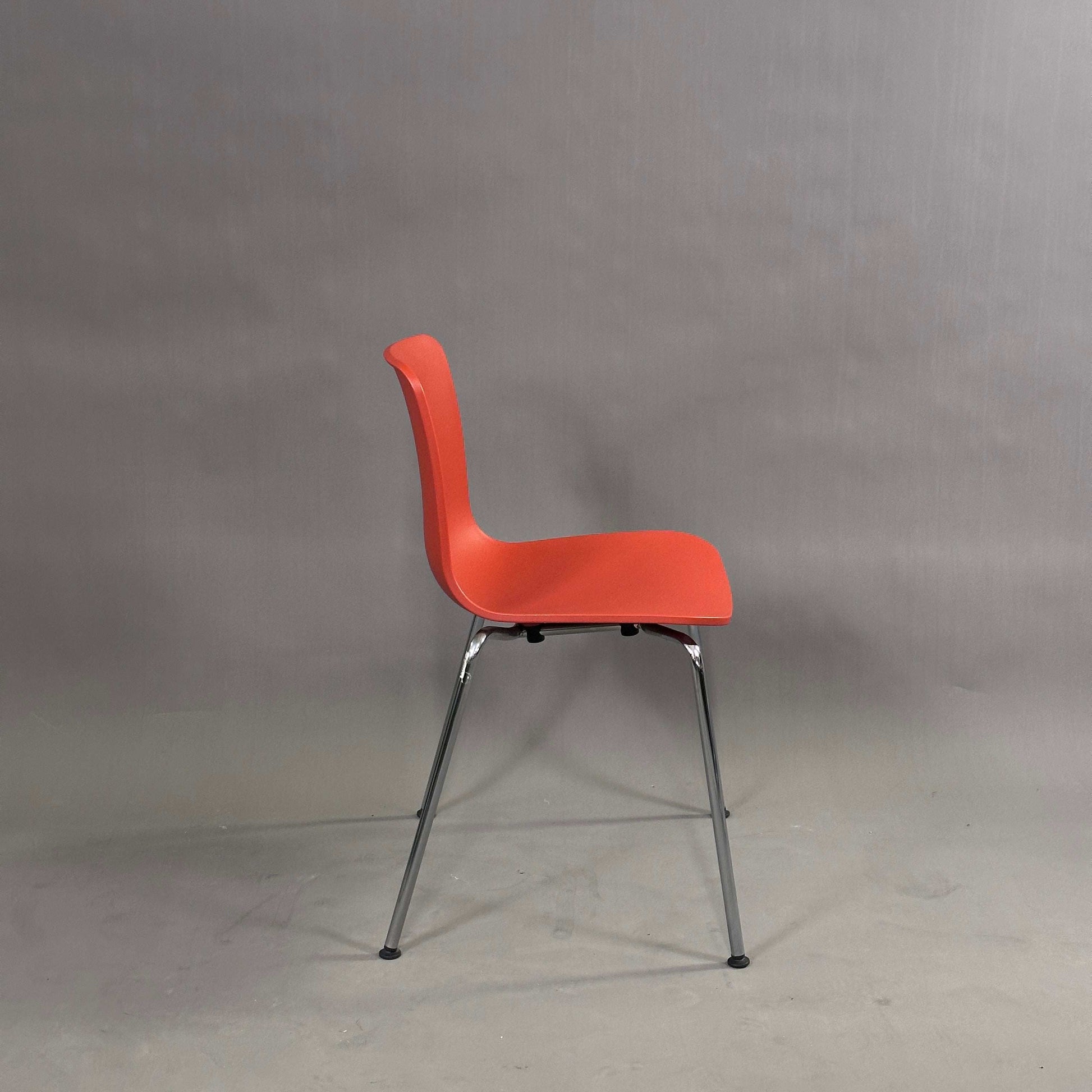 Vitra HAL Schalenstuhl mit roter Kunststoffschale und verchromtem Metallgestell, Seitenansicht vor neutralem Hintergrund