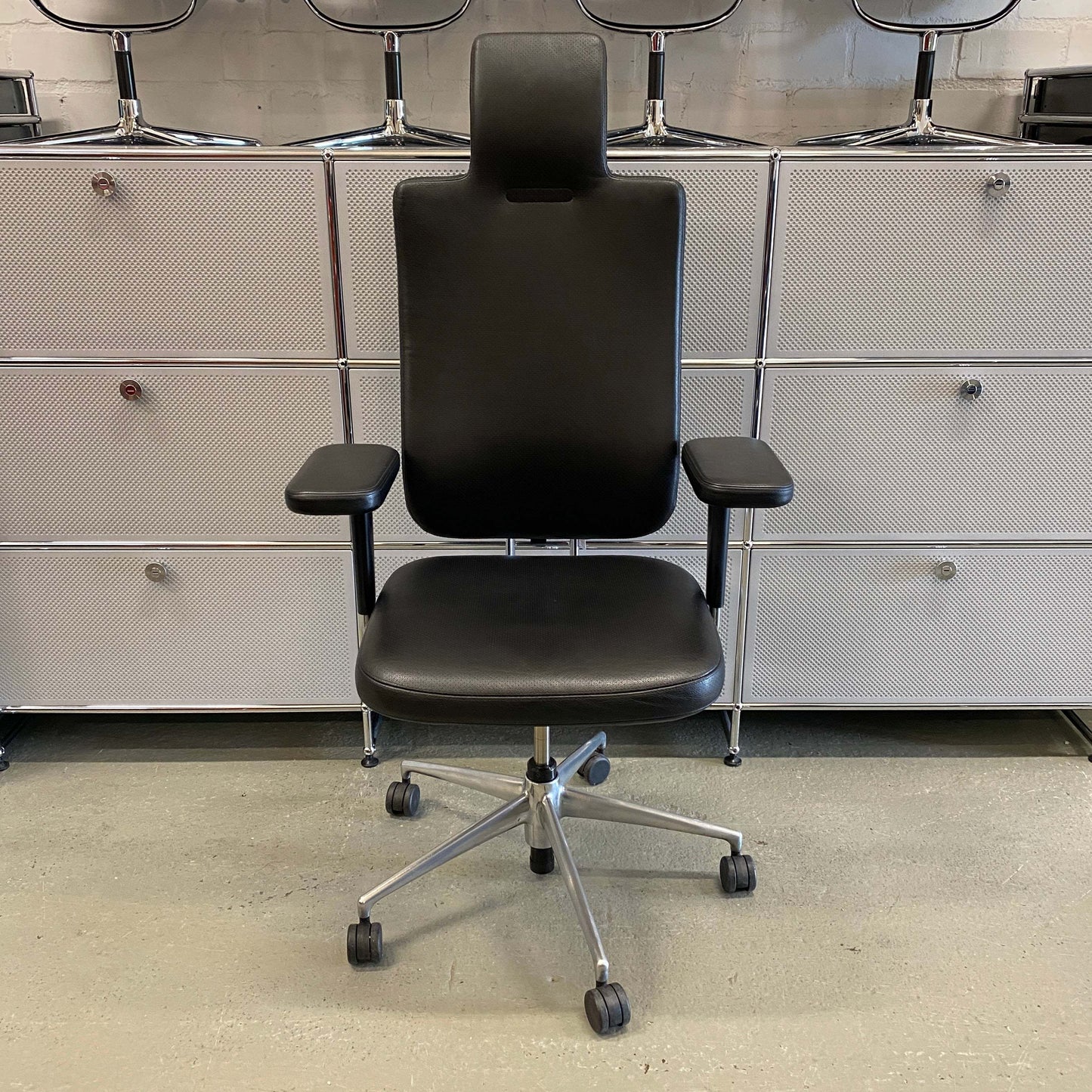 Black Vitra Headline Leder office chair with leather upholstery, chrome frame, adjustable armrests, headrest, and ergonomic back support.