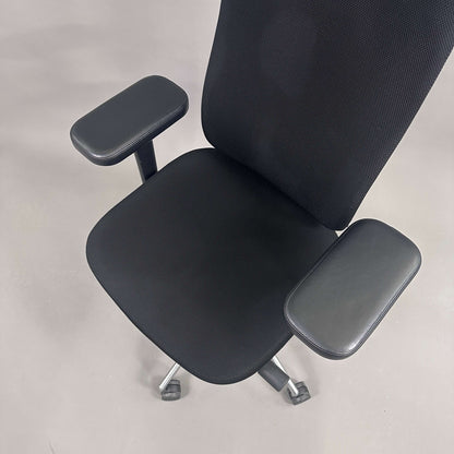 Vitra Headline black office chair with fabric seat, leather headrest, adjustable armrests, and chrome frame