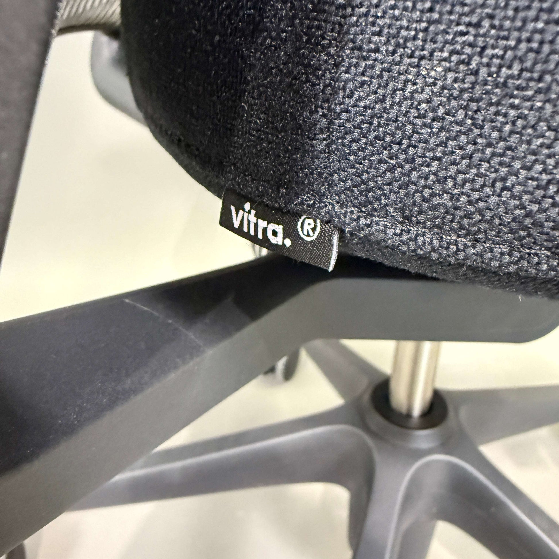 Close-up of Vitra ID Mesh office chair fabric and base with black seat and grey mesh backrest.