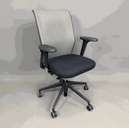 Vitra ID Mesh office chair with black seat, gray mesh backrest, and adjustable 3D armrests on wheels