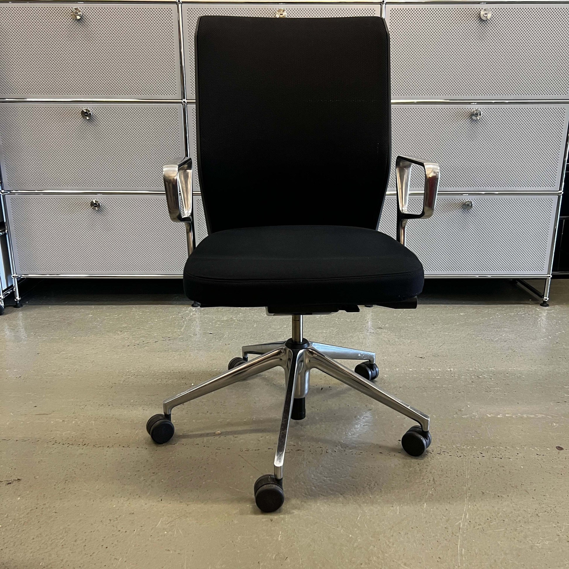 Black Vitra ID Mesh office chair with fine mesh material, aluminum armrests, adjustable height, lockable backrest, lumbar support, and universal caster wheels