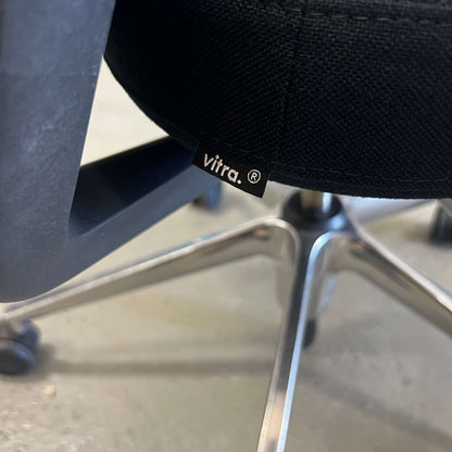 Close-up of black Vitra ID Mesh office chair with aluminum armrests and fine mesh material showing adjustable features and universal wheels