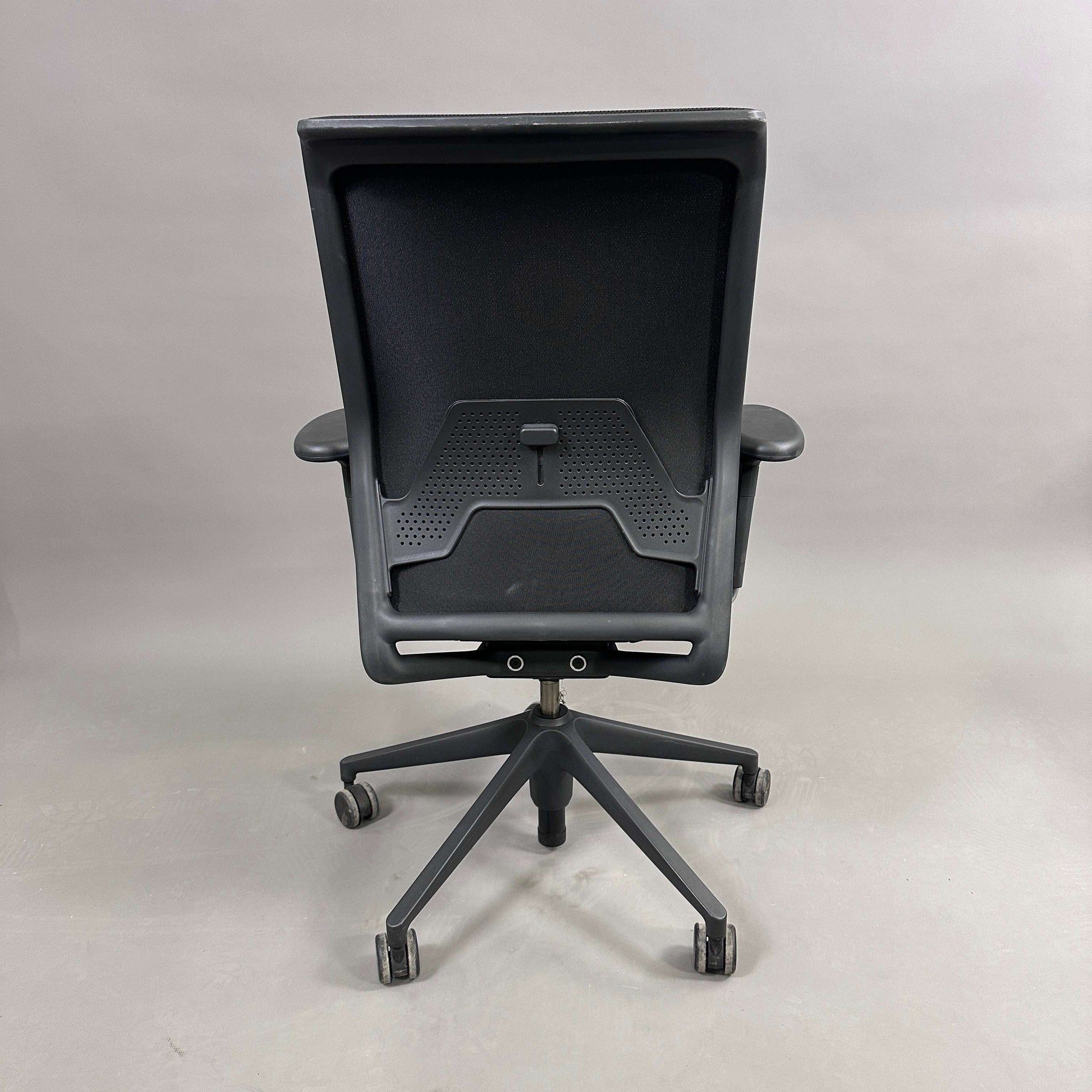 Black Vitra ID Mesh office chair with adjustable ergonomic features and mesh backrest viewed from the rear