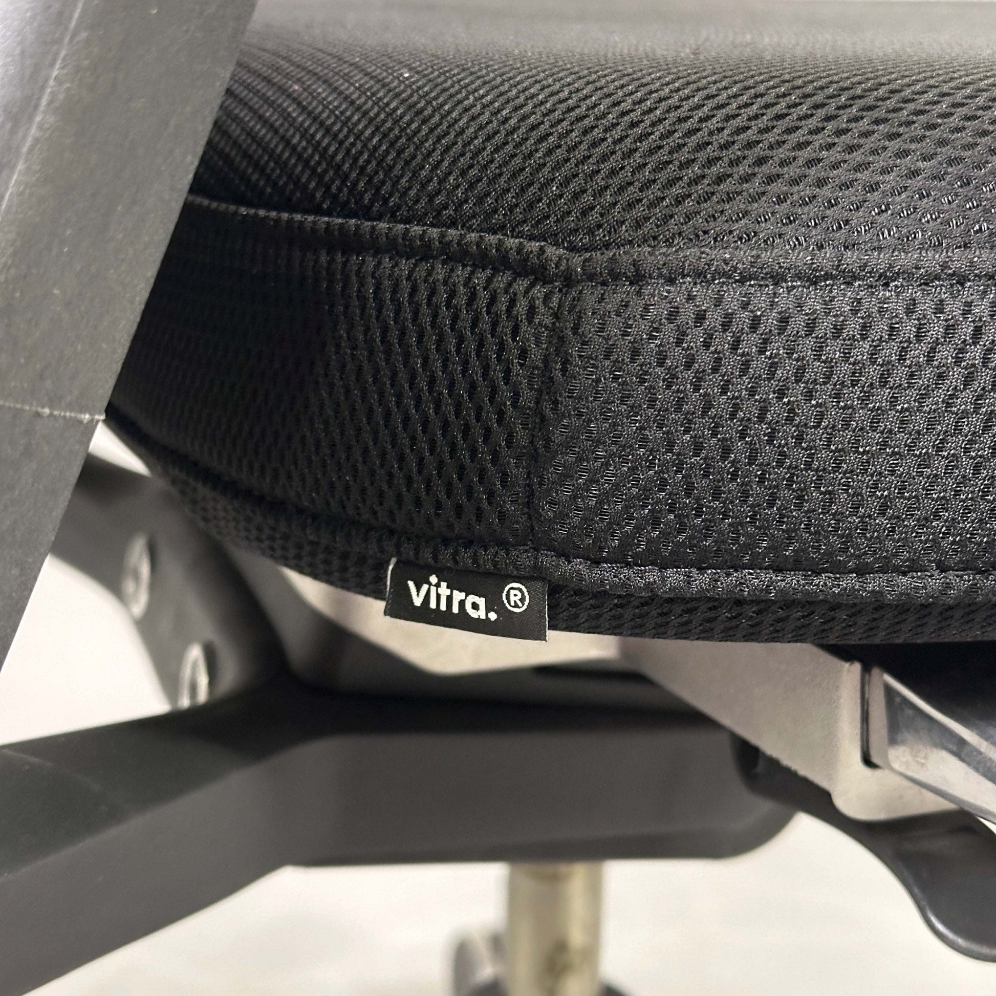 Close-up of black Vitra ID Mesh office chair seat with fine silk mesh fabric and adjustable ergonomic features