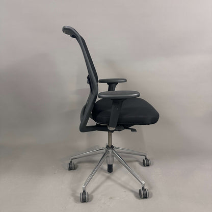 Schwarzer Vitra ID Mesh Bürostuhl mit verstellbarer Sitzhöhe, Sitztiefe, Lordosenstütze und Armlehnen auf chromfarbenem Alu-Gestell.