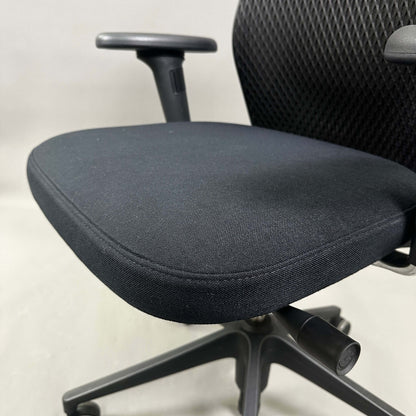 Close-up of Vitra ID Mesh black office chair seat and armrest with diamond mesh backrest and adjustable features