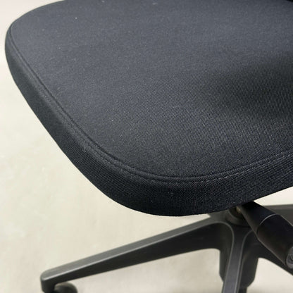 Close-up of Vitra ID Mesh black office chair with fabric seat and black plastic base