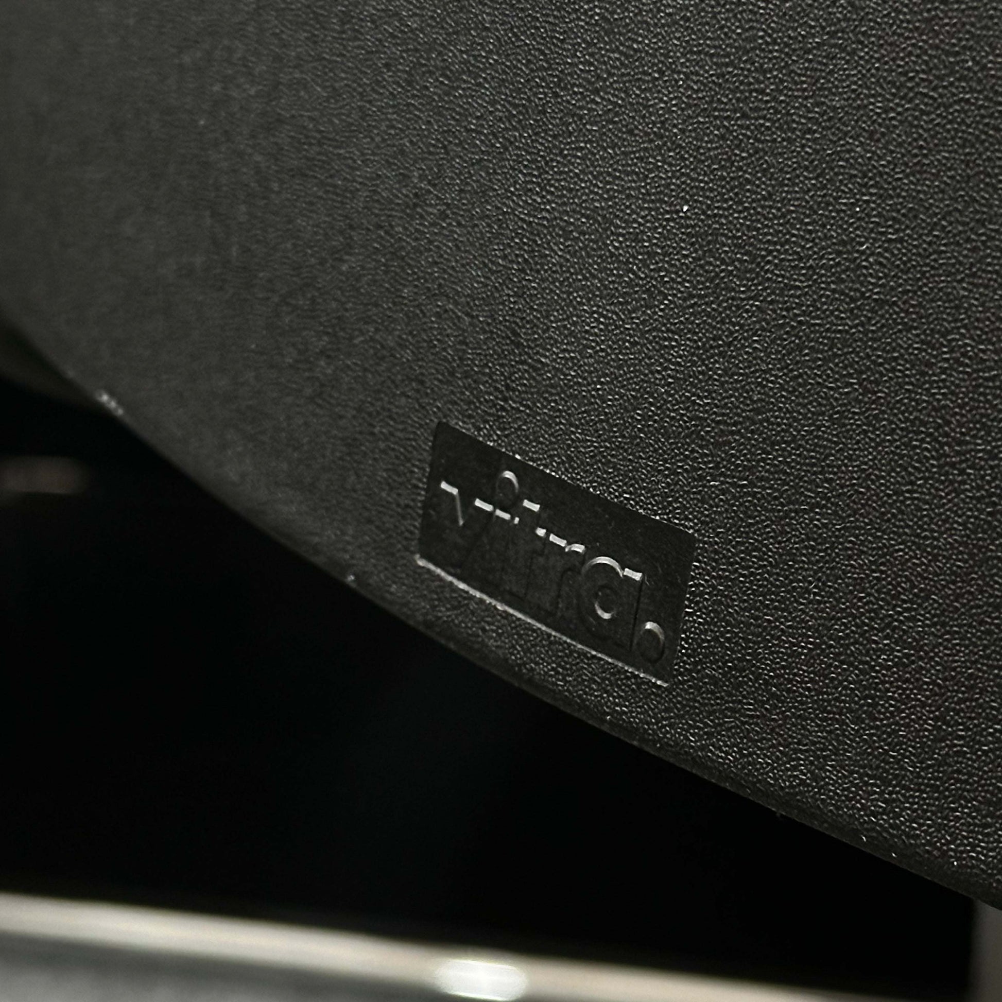 Close-up of the black Vitra ID Soft office chair with fabric cover and black plastic base highlighting ergonomic design.
