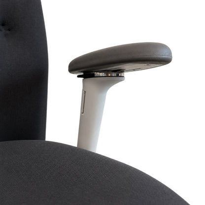 Vitra ID Trim Bürostuhl in Dunkelgrau mit verstellbarer 3D-Armlehne und gepolsterter Sitzfläche.