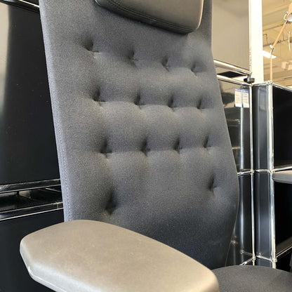 Adjustable Vitra ID Trim L office chair with black fabric seat and leather headrest