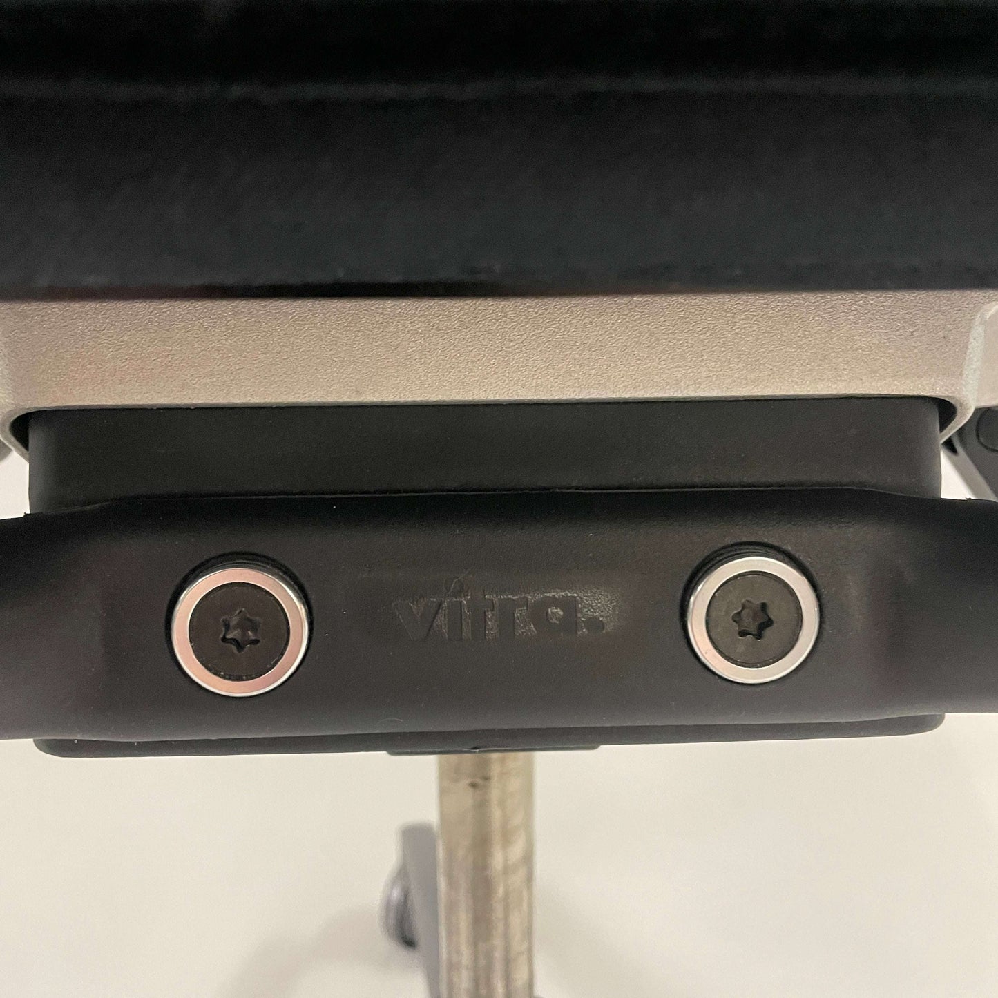 Close-up of adjustment mechanism on Vitra ID Trim L office chair with black fabric and leather headrest