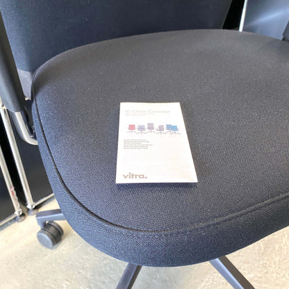 Close-up of black fabric seat of Vitra ID Trim L office chair with adjustable ergonomic features and black leather headrest