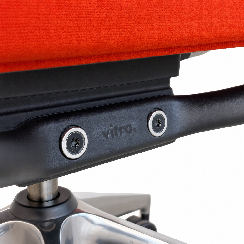 Vitra ID Trim Bürostuhl mit orange-rotem Stoffbezug, schwarzer Armlehnenhalterung und poliertem Aluminiumfuß.