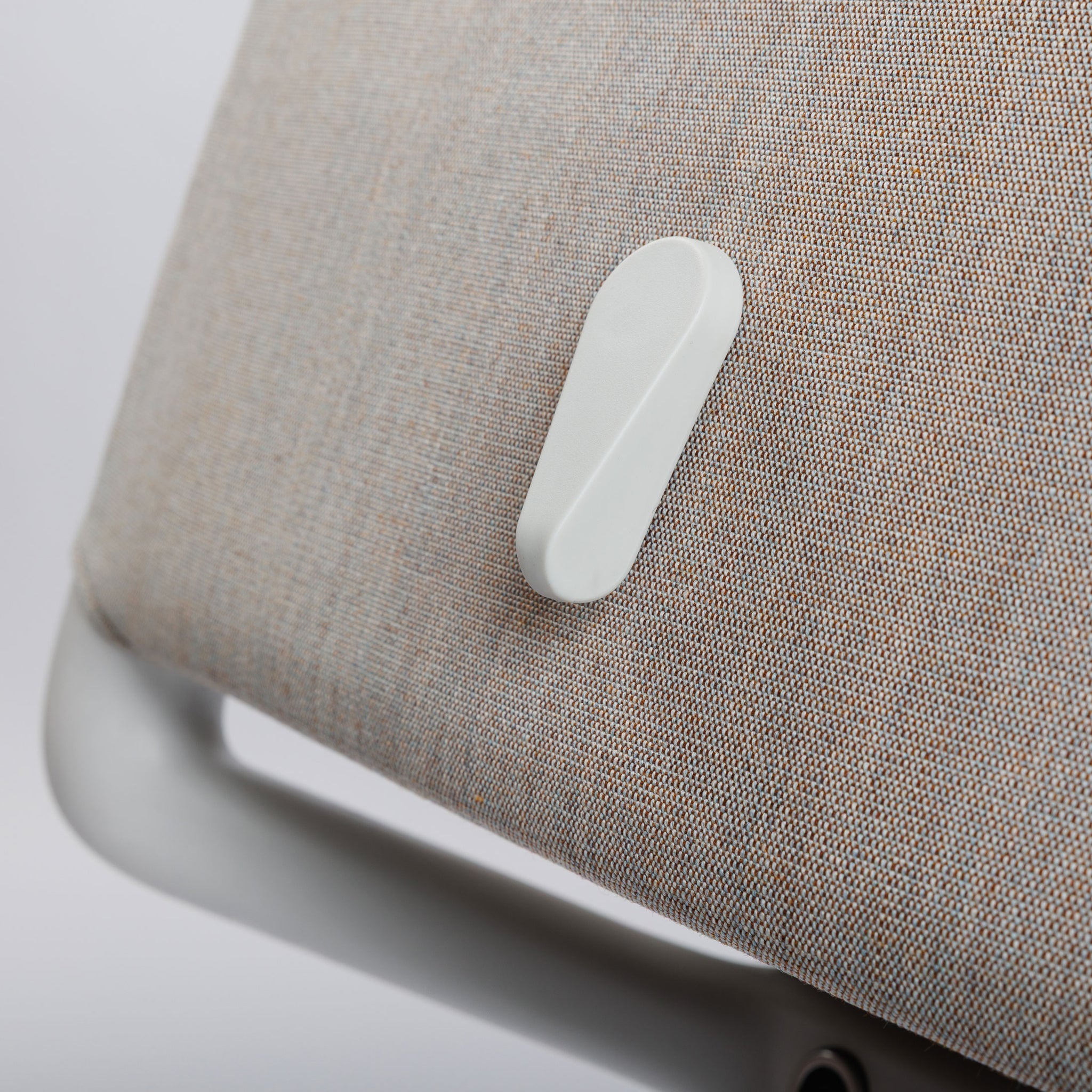 Nahaufnahme des Vitra ID Trim Bürostuhls mit grau/braunem Stoffbezug und weißem Verstellhebel.