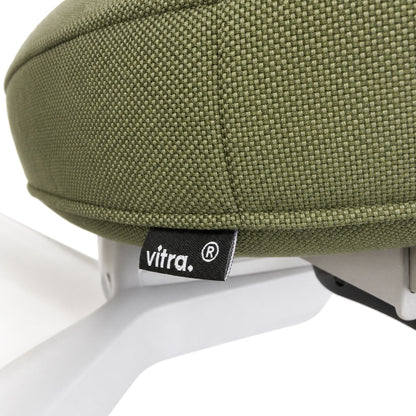 Detailansicht des Vitra ID Trim Bürostuhls mit olivgrünem Stoffbezug und Vitra-Label am Sitz.