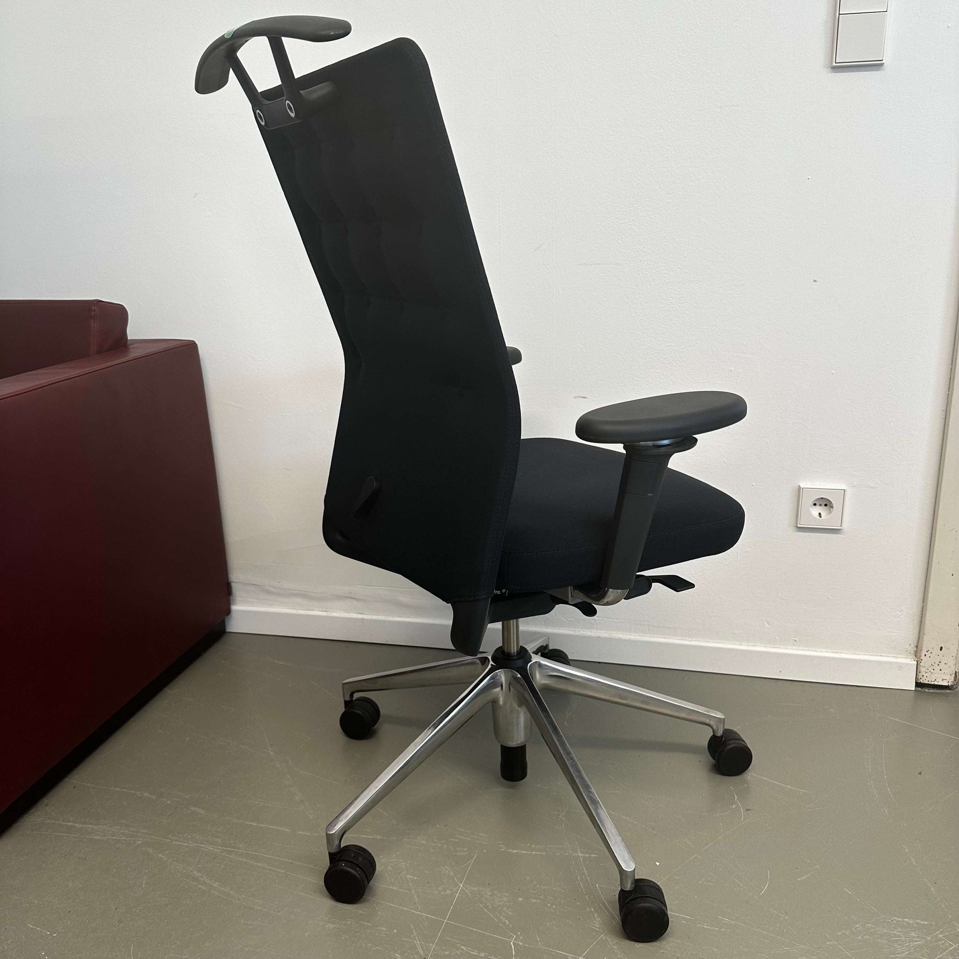 Black Vitra ID Trim ergonomic office chair with adjustable armrests and high backrest on caster wheels