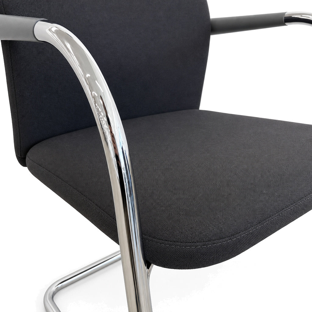 Vitra ID Visitor Soft Freischwinger in Dunkelgrau mit verchromtem Metallgestell und Armlehnen.