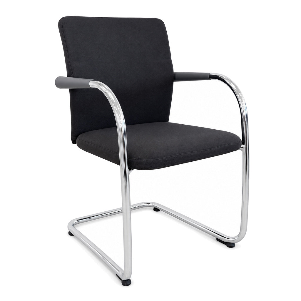 Vitra ID Visitor Soft Freischwinger in Dunkelgrau mit verchromtem Gestell und Armlehnen vor weißem Hintergrund.