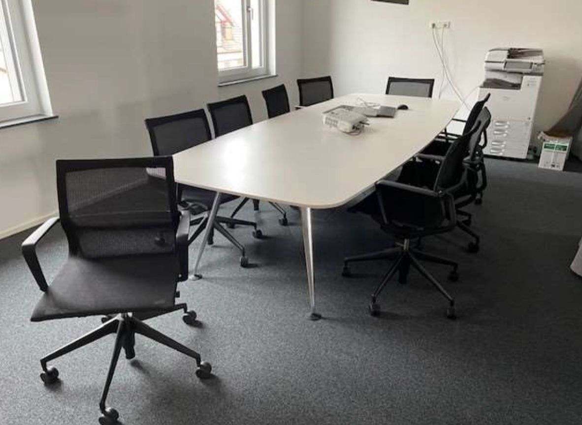 Vitra Medamorph large white meeting table with black mesh office chairs in modern conference room