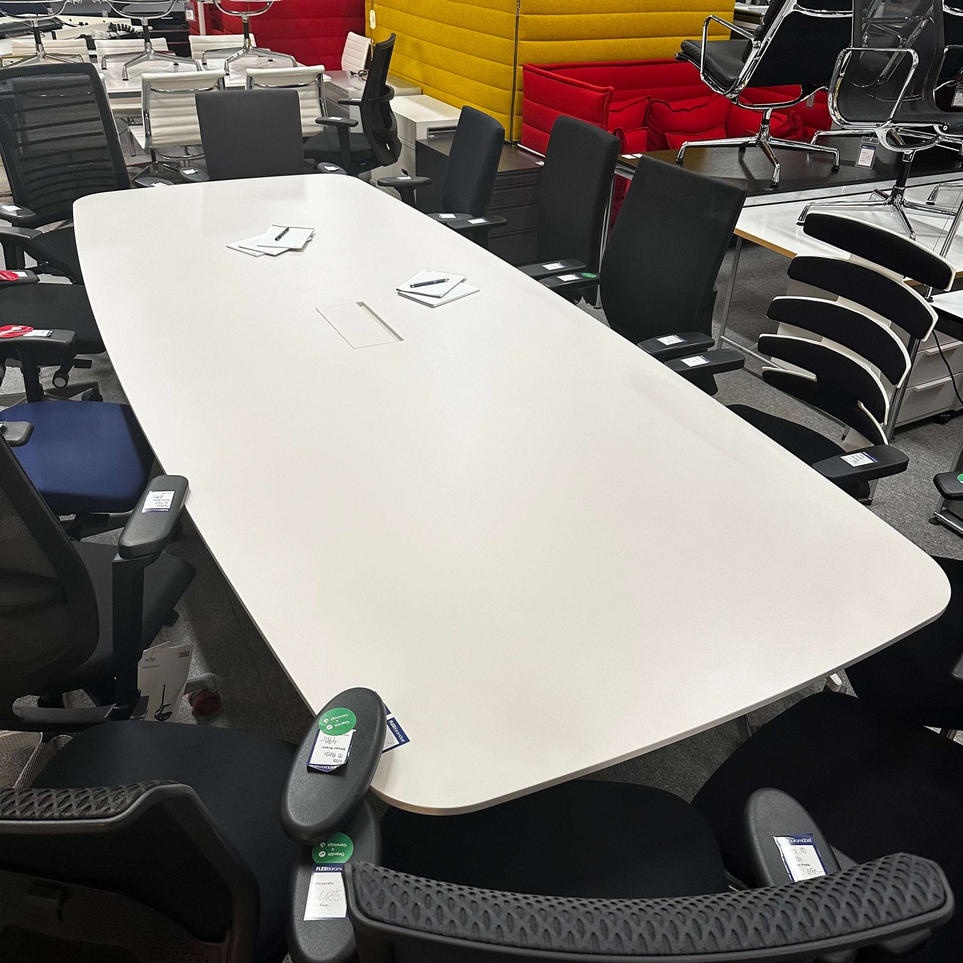Vitra Medamorph large white conference table with ergonomic black office chairs in modern meeting room