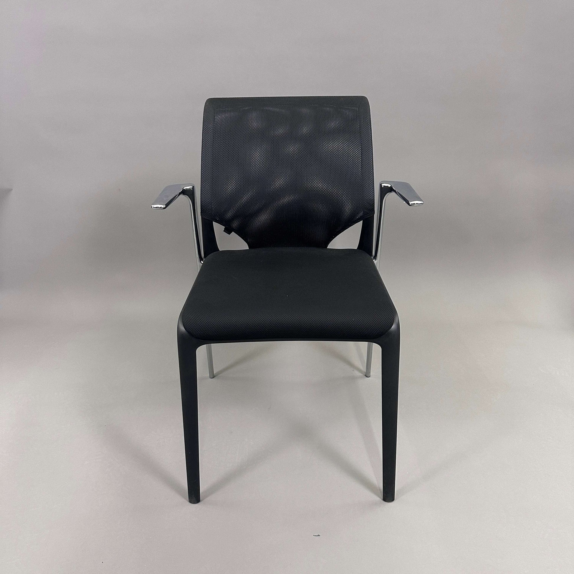 Vitra Medaslim chair with black cushioned seat, mesh backrest, and chrome armrests and frame