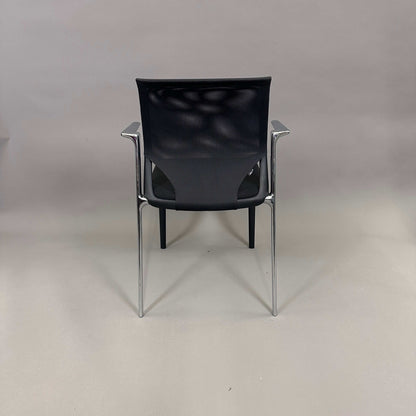 Vitra Medaslim chair with black mesh backrest, padded black seat, and chrome armrests and frame viewed from the back