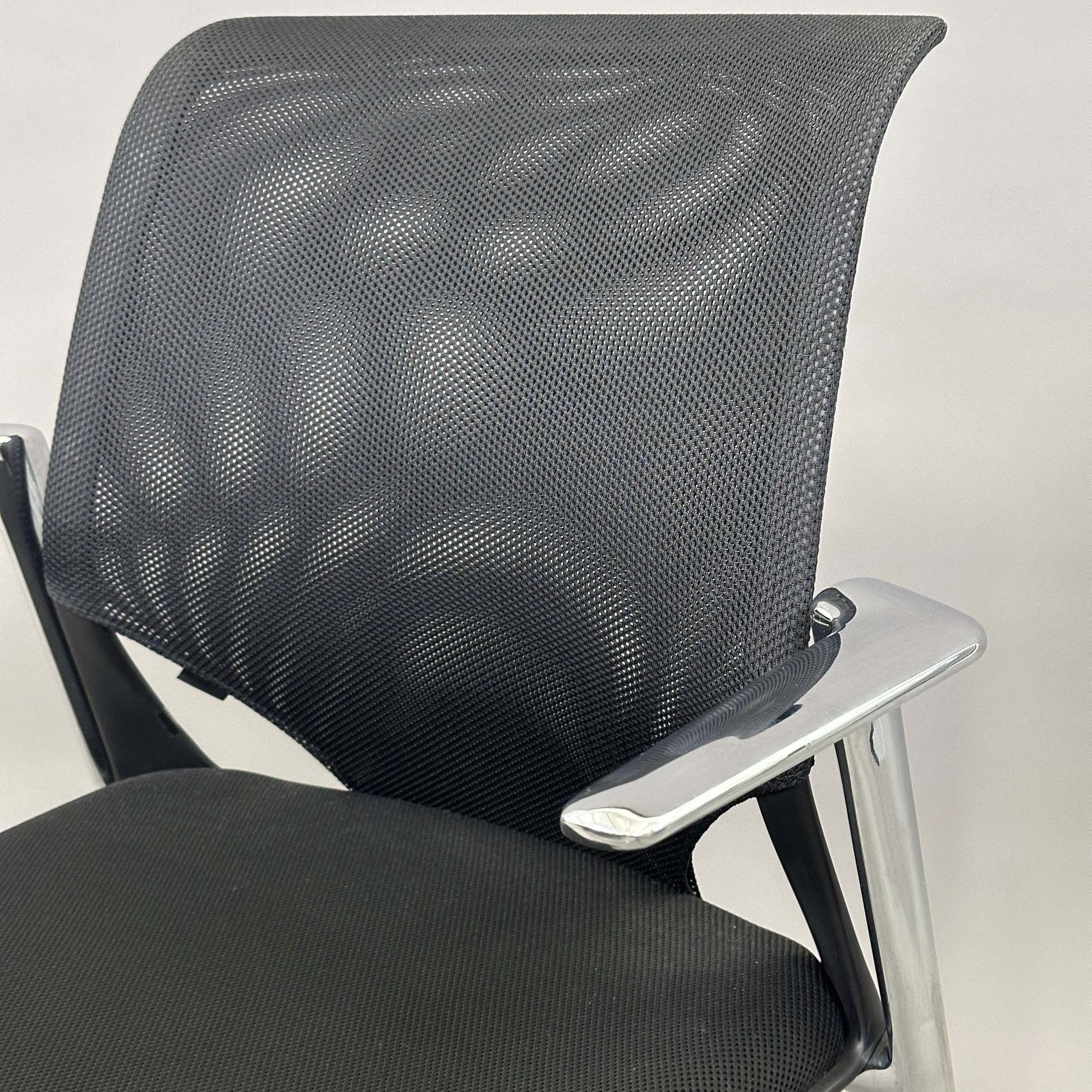 Vitra Medaslim office chair with black mesh backrest, black upholstered seat, and chrome armrests and frame