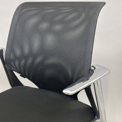 Vitra Medaslim office chair with black mesh backrest, black upholstered seat, and chrome armrests and frame