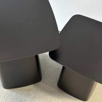 Two matte black Vitra Metal Side Tables in sizes M and S with rounded edges and sleek metal design on a light floor.