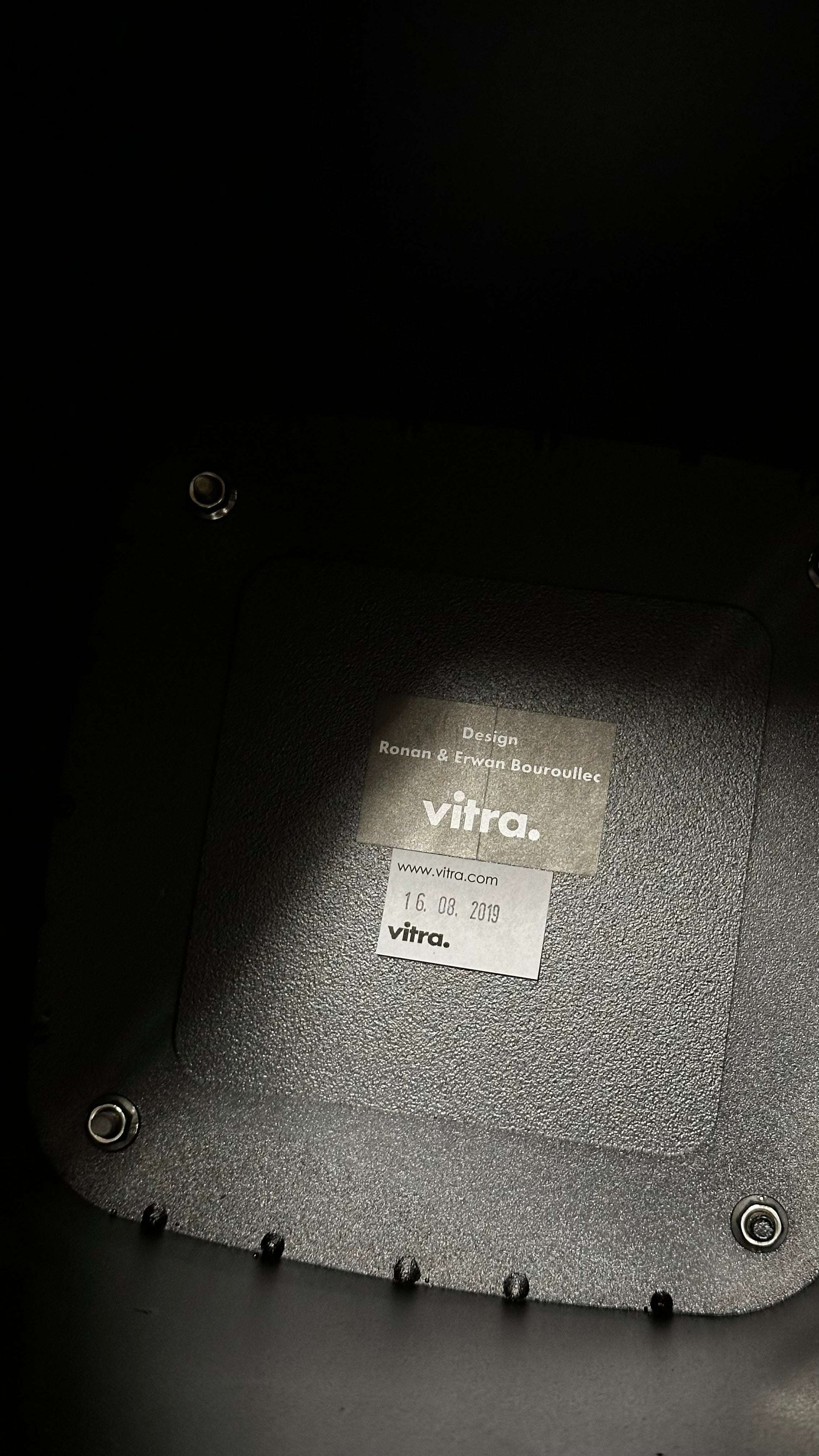 Bottom view of a matte black Vitra Metal Side Table Größe S made of metal with branded label and screws, suitable for indoor and outdoor use.