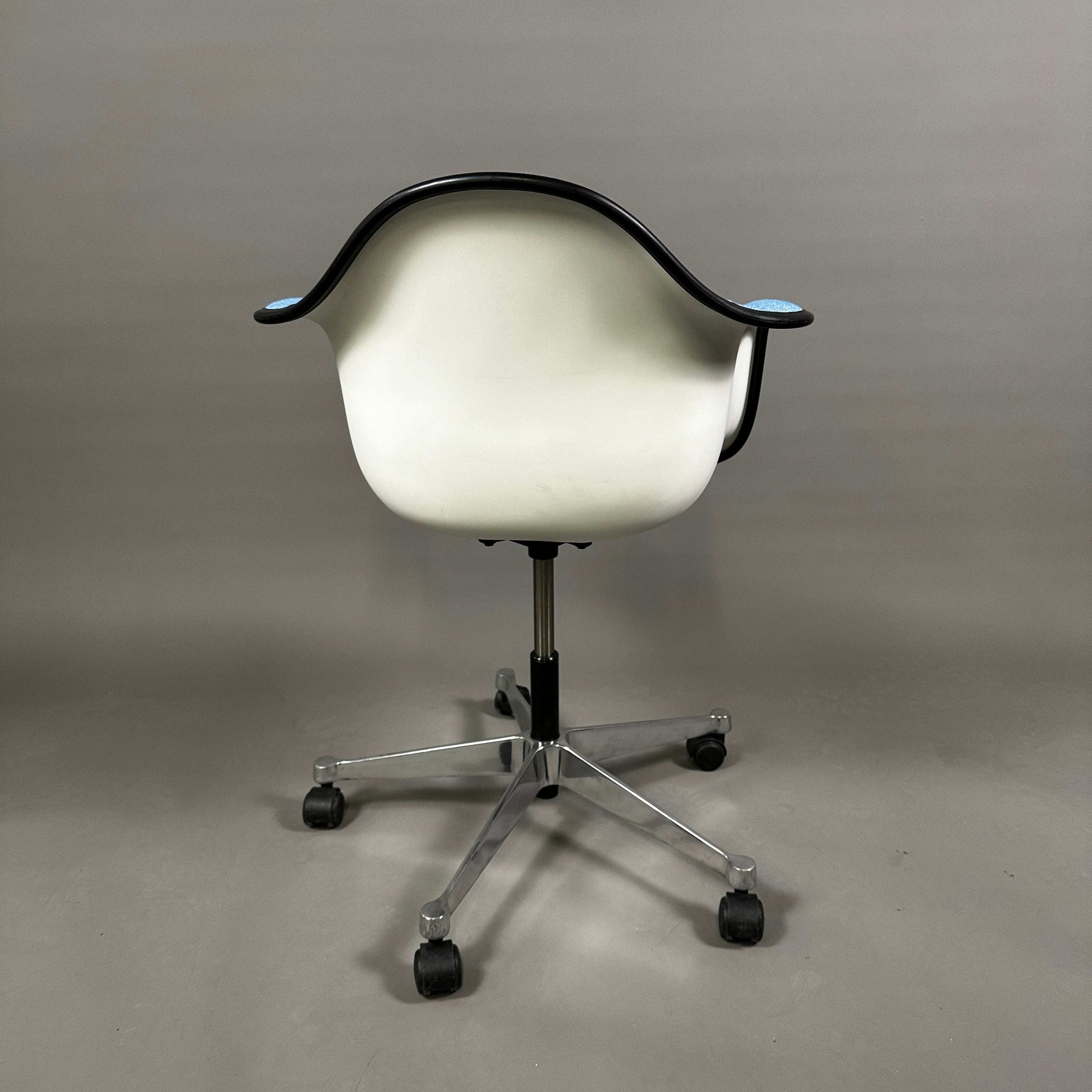 Vitra PACC Plastic Arm Chair mit weißer Sitzschale und blauem Hopsak Stoffbezug auf Rollgestell