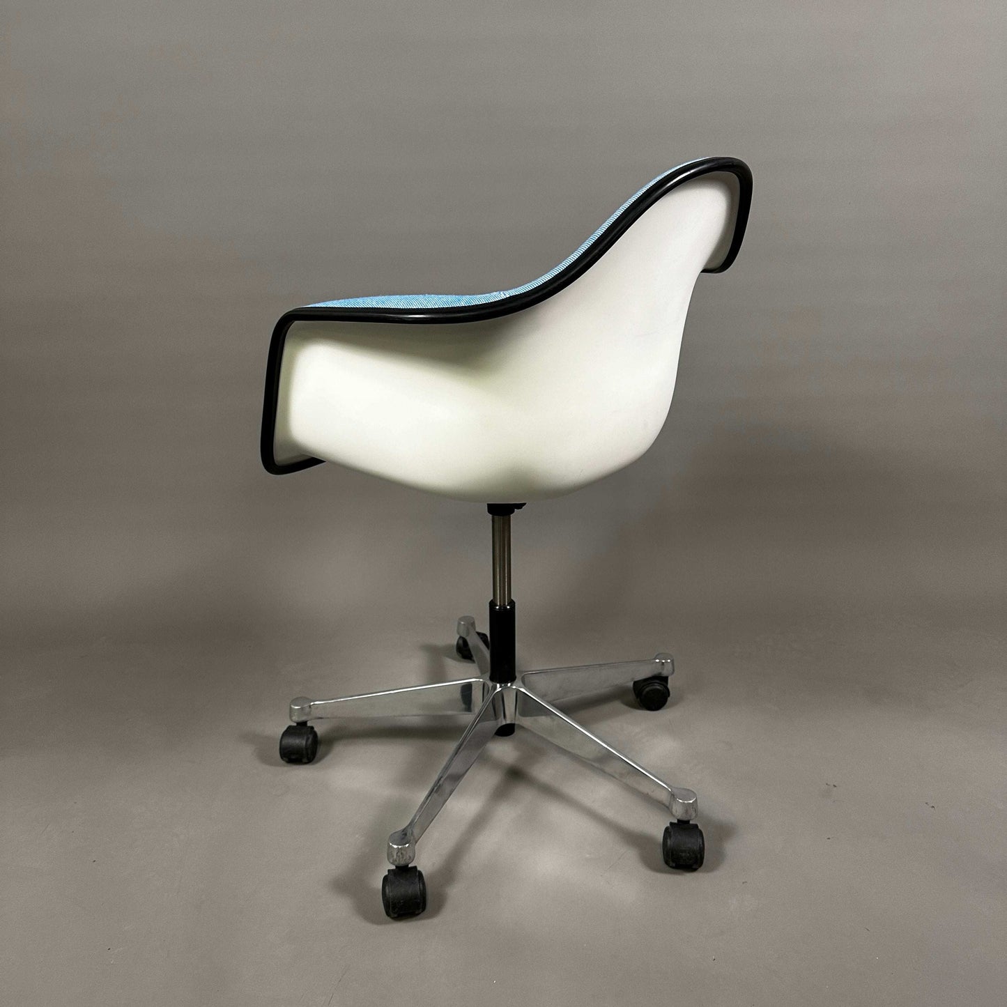 Vitra PACC Plastic Arm Chair mit weißer Sitzschale, blauem Hopsak-Stoffbezug und schwarzem Rand auf Drehgestell mit Rollen