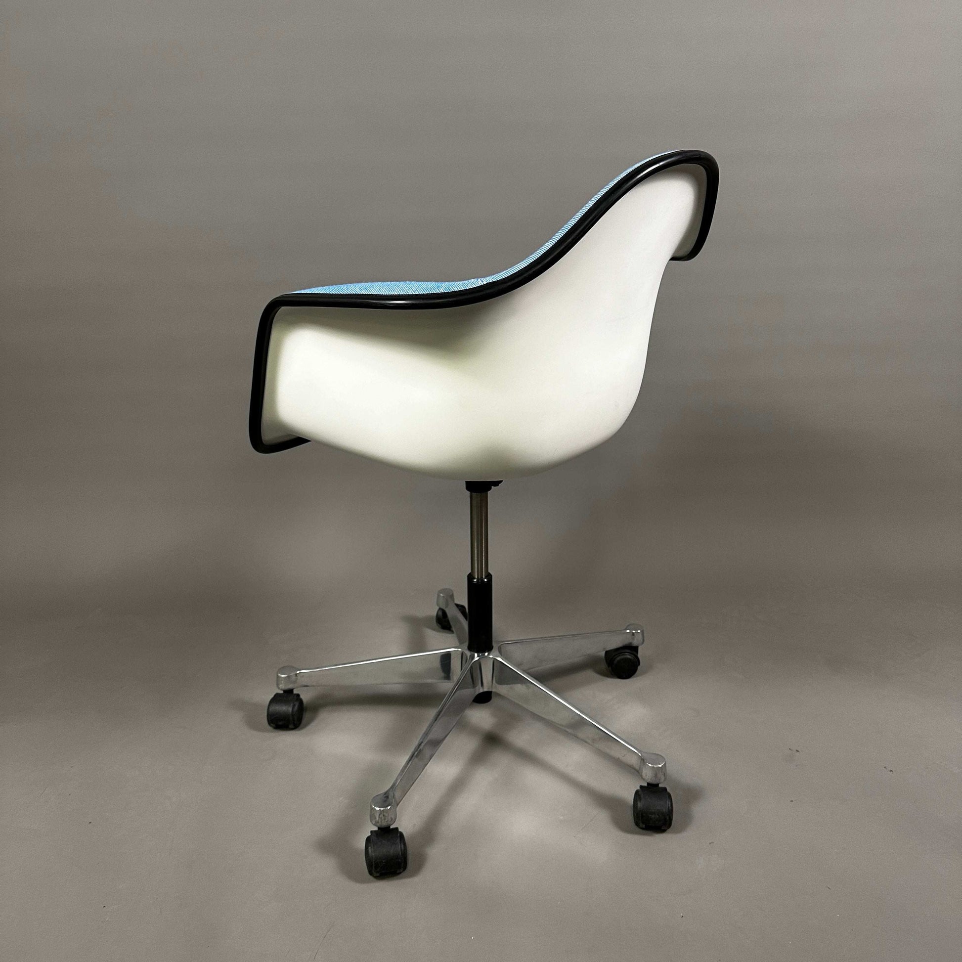 Vitra PACC Plastic Arm Chair mit weißer Sitzschale, blauem Hopsak-Stoffbezug und schwarzem Rand auf Drehgestell mit Rollen