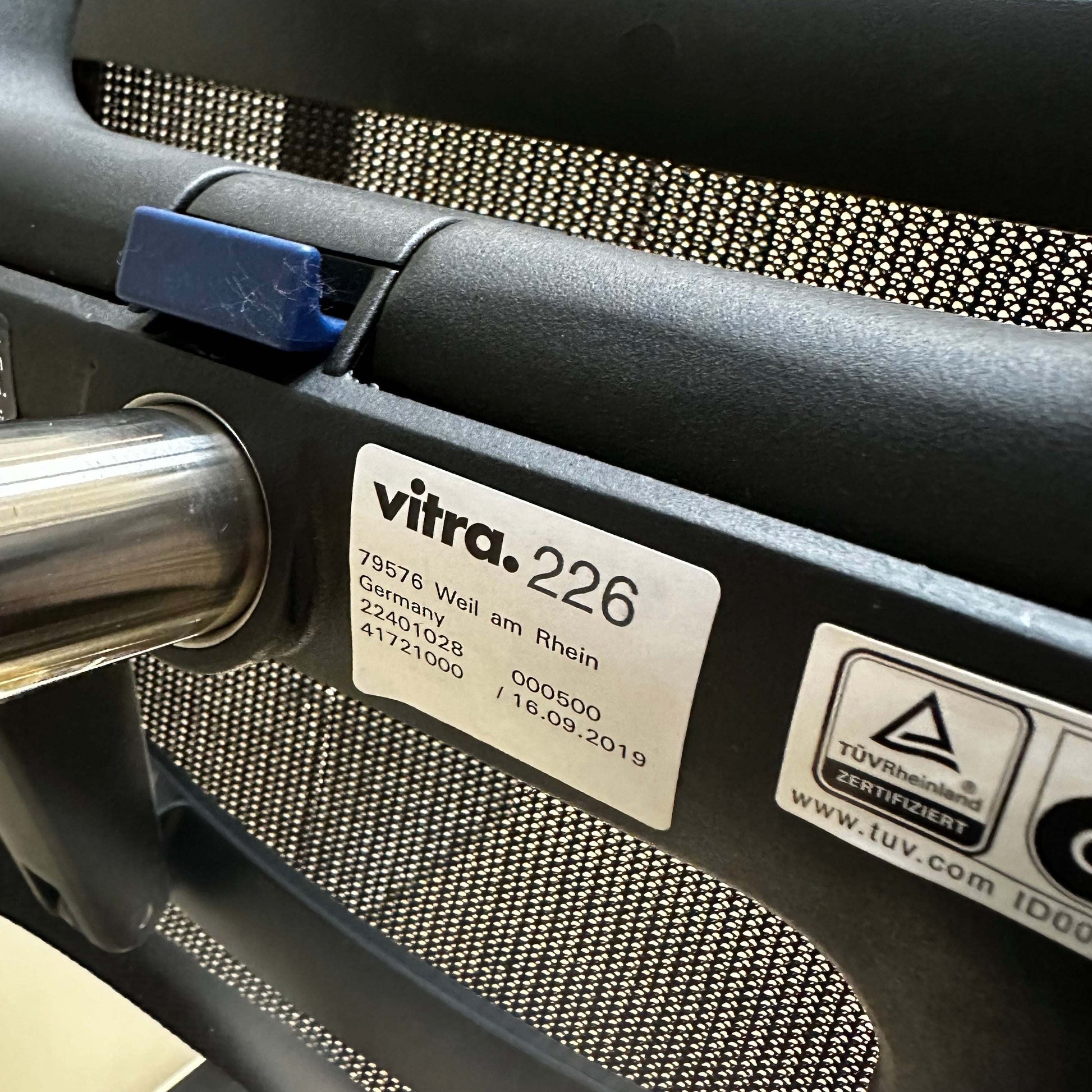 Close-up of Vitra Physix Bürostuhl label and adjustment mechanism showing manufacturing details and certification marks