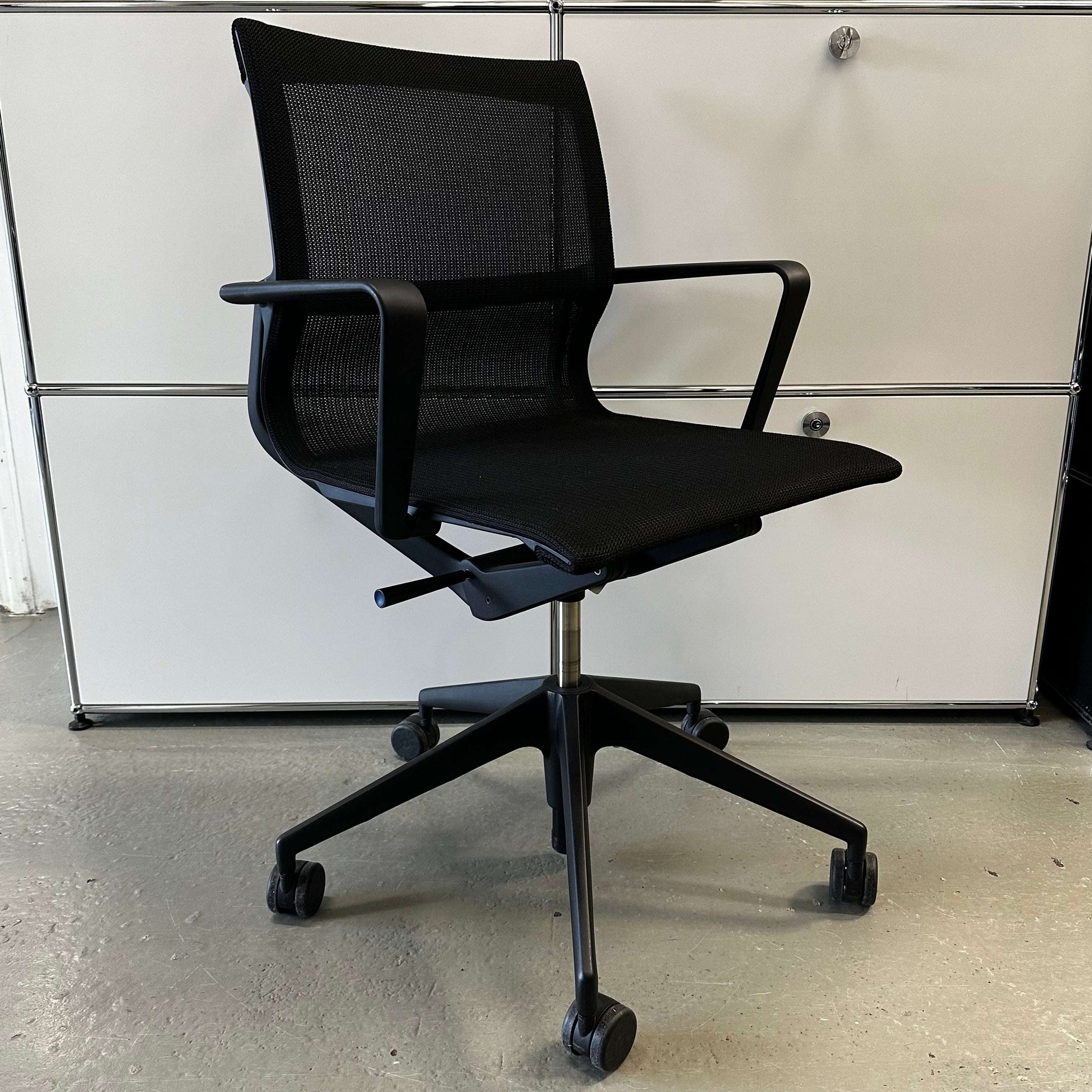Black ergonomic Vitra Physix Bürostuhl office chair with mesh back and adjustable height on caster wheels