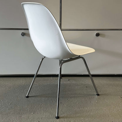 White Vitra Plastic Side Chair with chrome legs and minimalist design in a modern indoor setting