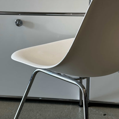 White Vitra Plastic Side Chair with minimalist plastic seat and chrome legs in modern interior setting