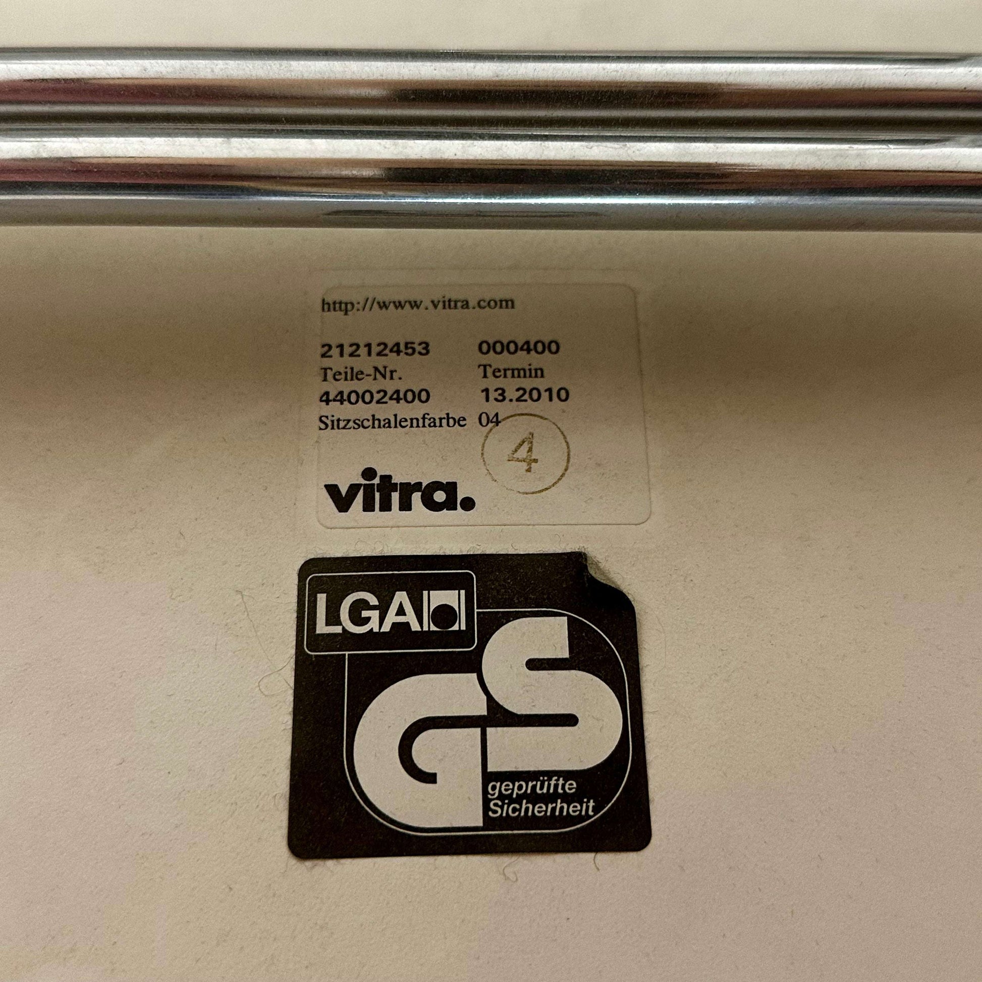 Vitra Plastic Side Chair certification labels on chair underside showing model and safety approvals