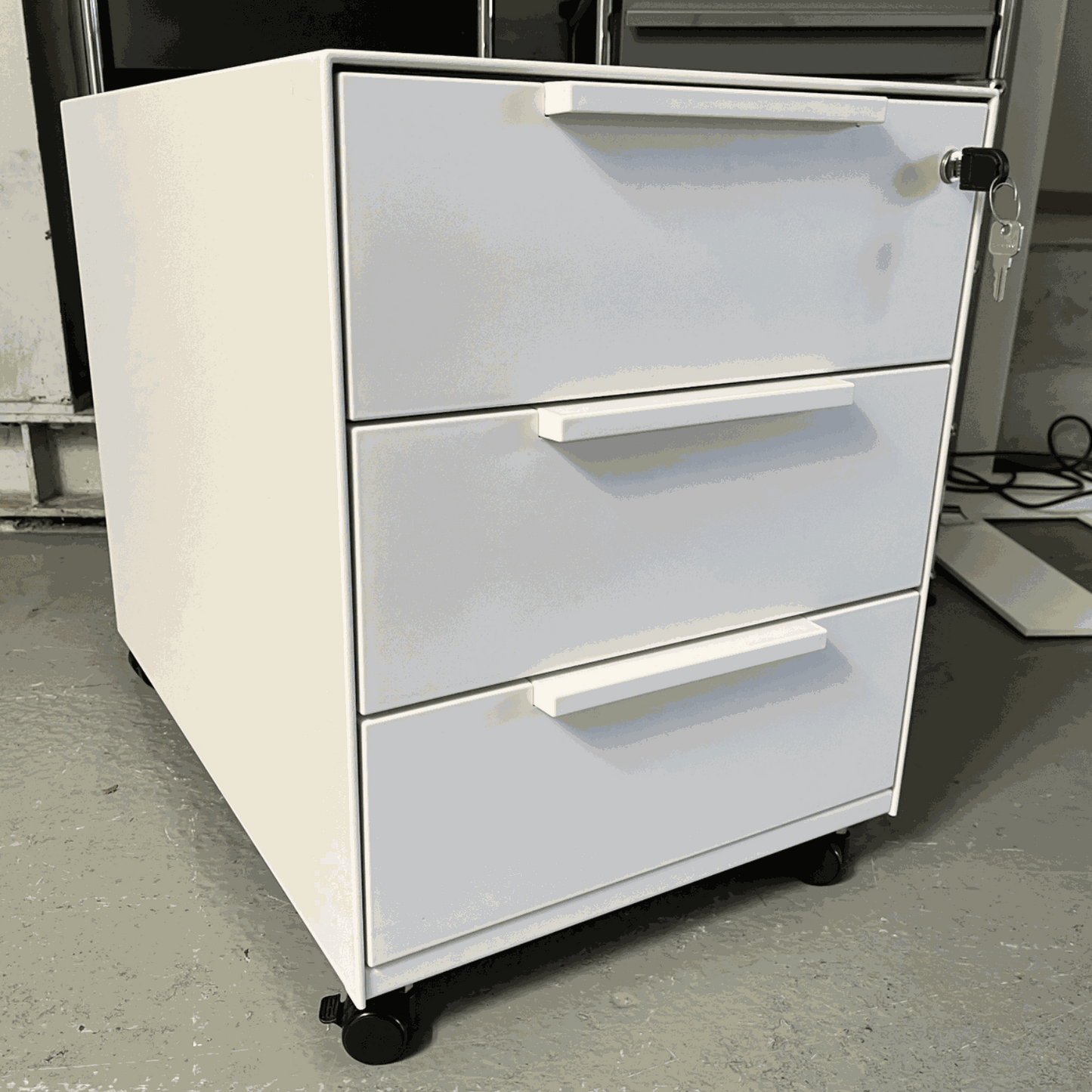 White Vitra Rollcontainer with metal body, plastic fronts, three drawers, and wheels, measuring 42x54x61cm